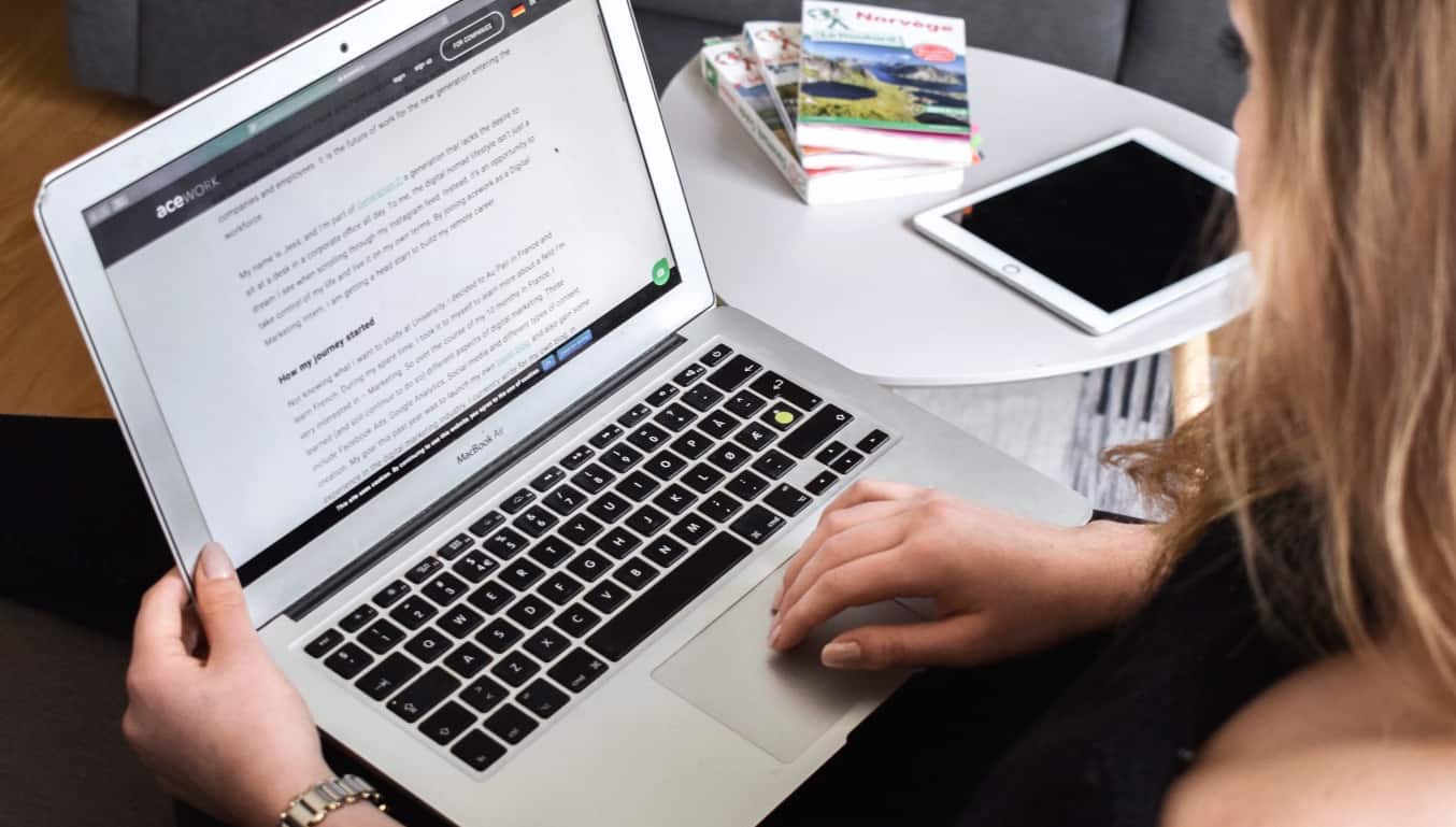 women-working-on-laptop-with-books-on-table