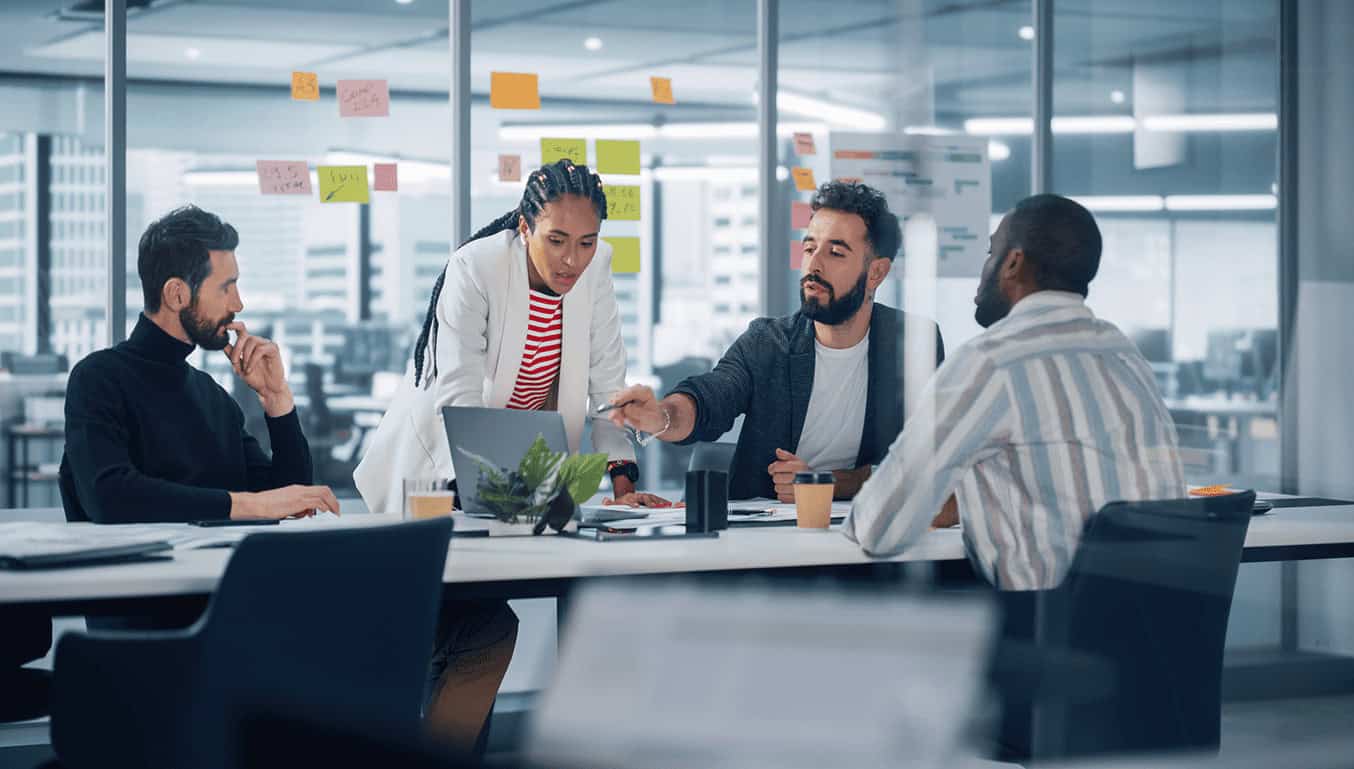meeting-room-4-eployees-gathered-around-a-computer