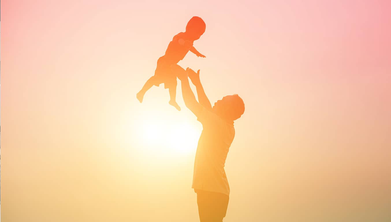 man-playing-with-a child-in-sunset