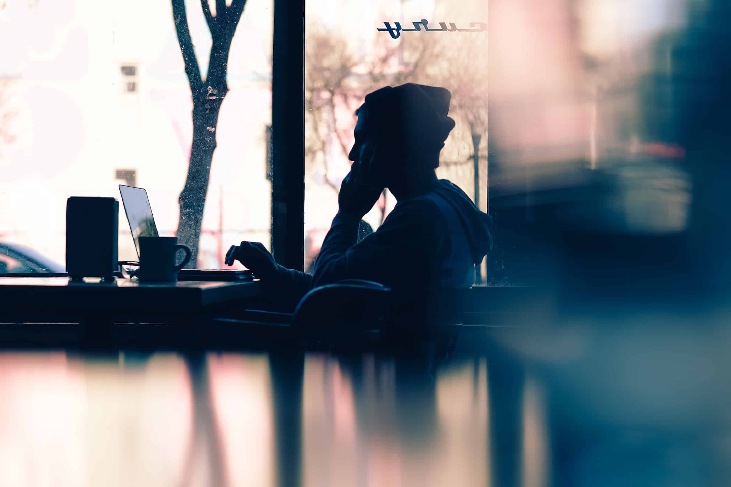 Shadow of a person with a laptop