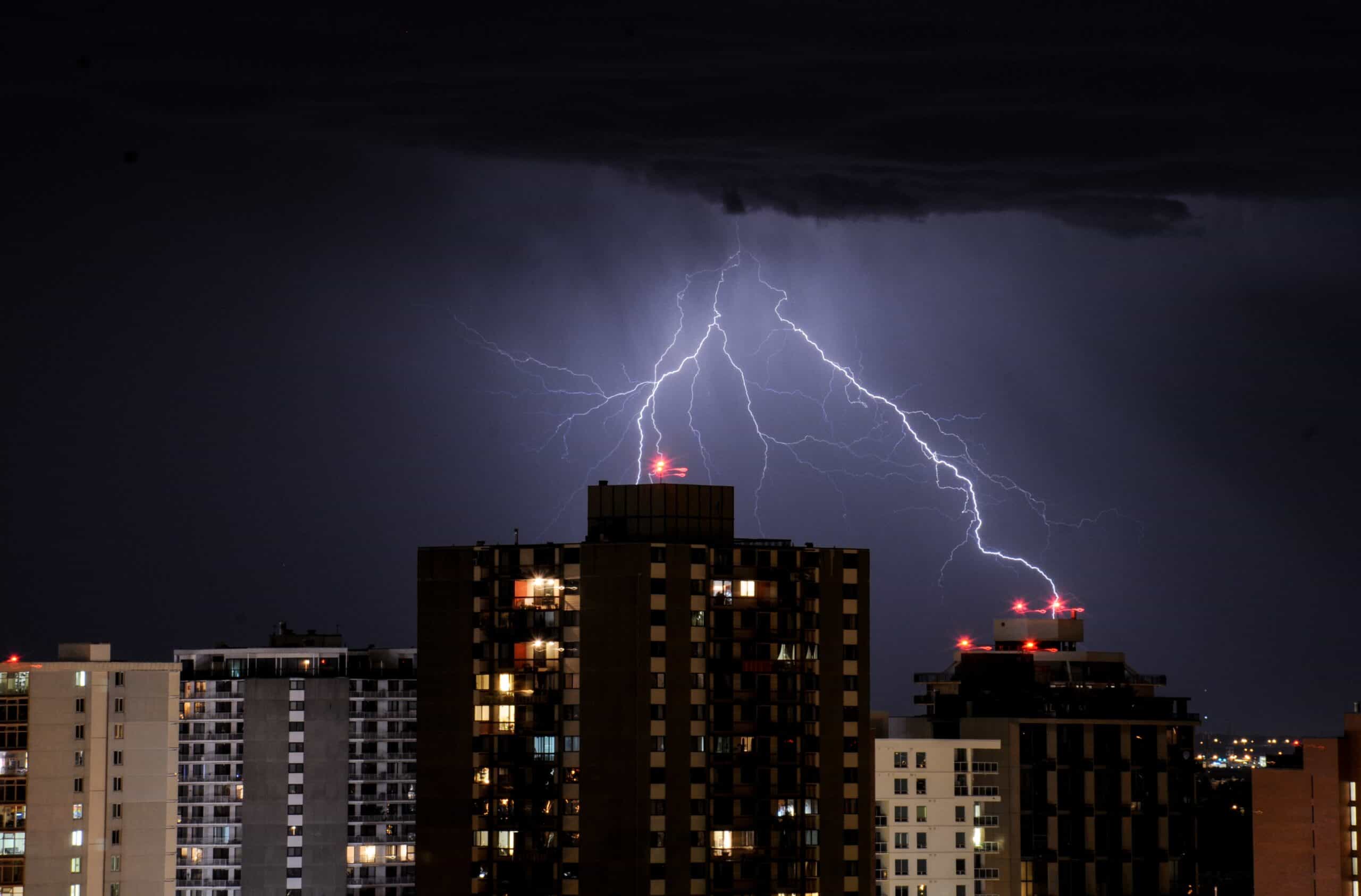 buildings-night-sky-lightning-black-clouds