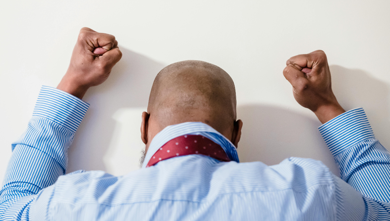 angry person from behind with fists on the wall