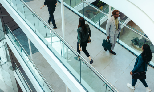 A group of diverse businesspeople walking briskly in a contemporary office space