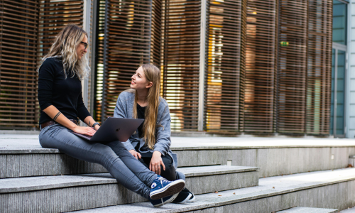 Three Persons Sitting on the Stairs Talking With Each Other