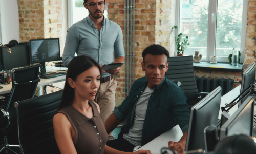 people sat around a computer screen