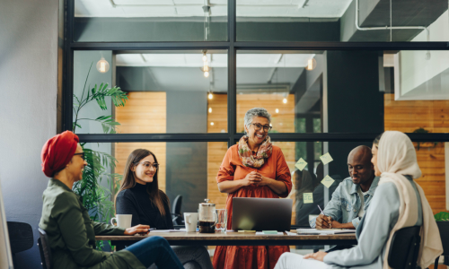 a group of workers around a table in a meeting room